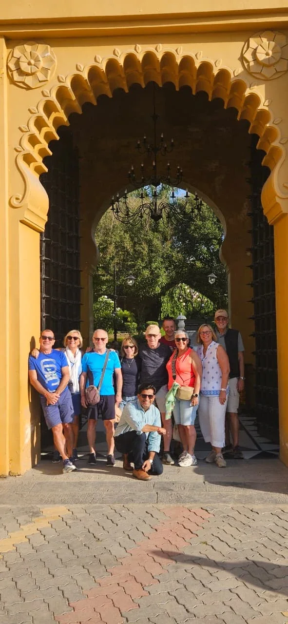 Travelers gathered beneath an ornate yellow heritage arch in Rajasthan