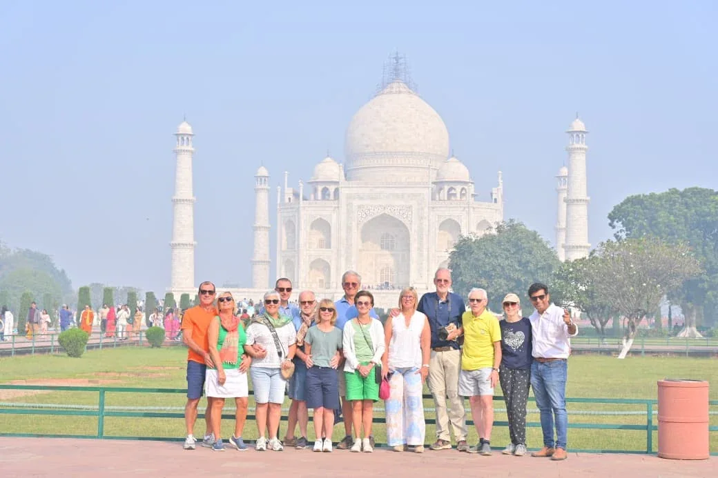 Travelers standing on the gardens in front of the Taj Mahal